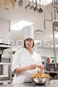 Female Chef Working In Commercial Kitchen