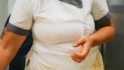 Female chef working hard preparing fresh homemade Italian pasta, wearing a .. Stock Photos