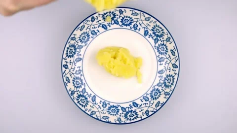 A female chef's hand puts mashed potatoes into a plate with a spoon. 스톡 동영상 262238045