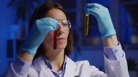 Female chemist comparing liquids in test tubes Stock Footage 124711101