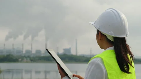 Female chief engineer working with laptop at coal plant in morning. Stockbeeldmateriaal 223640714
