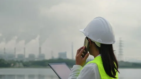 Female chief engineer working with laptop at coal plant in morning. Video stock 223641393