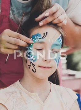 Female child face painting, making butterfly process Stock Photos