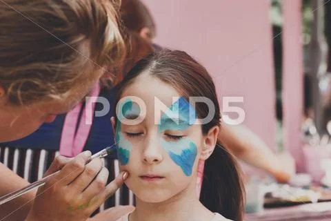 Female child face painting, making butterfly process Stock Photos