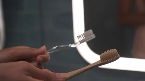 Female Choosing Between Plastic and Bamboo Wooden Tooth Brush.  4K Stock Footage 121835418