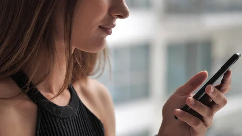 Female clicks smartphone on window background 4k Stock Footage 124902194