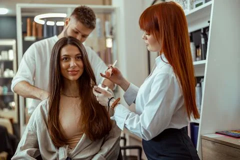 Female client getting professional help makeup and hairstyle in beauty salon Stock Photos