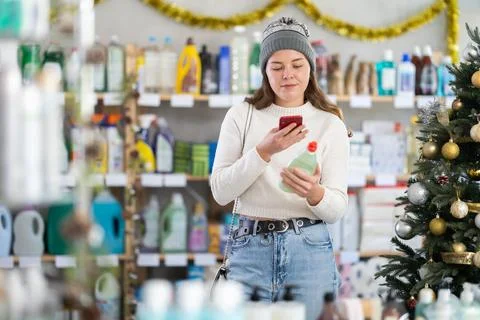 Female client scanning QR code on package dishwashing detergent Stock Photos