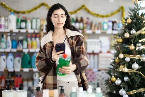 Female client scanning QR code on package dishwashing detergent Stock-Fotos