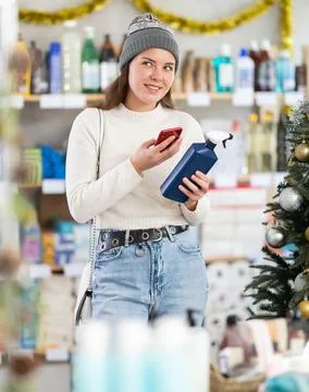 Female client scanning QR code on package tile cleaner spray Stock Photos