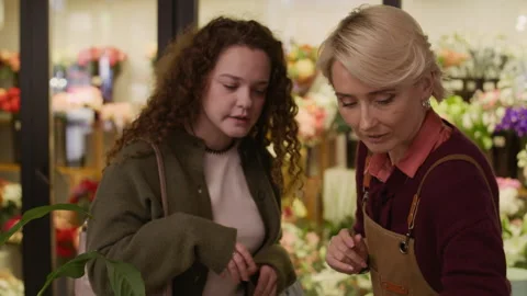Female Client Talking to Consultant Showing Candleholders in Gift Store Stock Footage 321339219