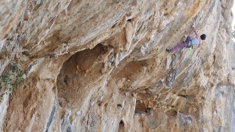 Female climber working hard on a extremely overhanging steep limestone Stock Footage 70131382