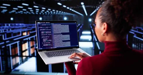 Female Cloud Engineer Configuring AI Technology In Data Center Server Room. Stock Photos