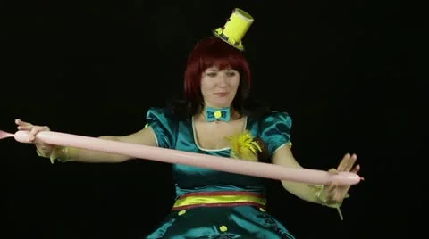 Female clown makes balloon dog Stock Footage