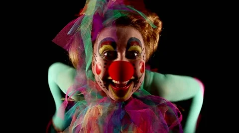 Female clown is making grimaces in front of  black background Video stock 40973847