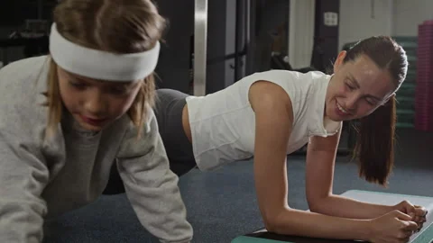 Female Coach and Little Client Doing Plank Exercise on Step Platforms in Gym Stock Footage 343383553