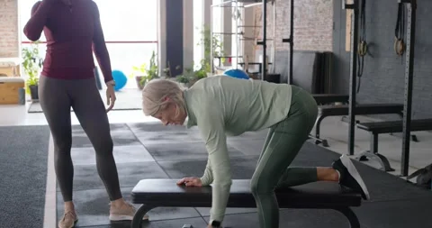 Female coach cueing as client picking dumbbell bracing bench rowing switching Vídeos de archivo 342066165