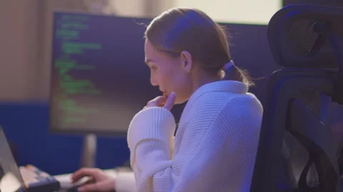 Female coder working. Female developer studying terminal output late at night Stock Footage 347879614