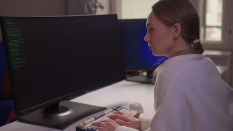 Female coder working. Female developer studying terminal output late at night Stock Footage 347879656