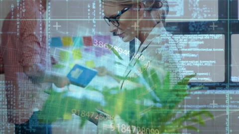 Female colleague tapping tablet in tech office animating code as peer pointing Stock Footage 311663241