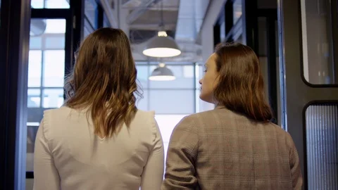 Female Colleagues Chat While Walking Through Modern Office Space Stock Footage 97318549