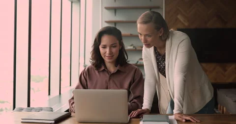 Female colleagues using laptop work together on collaborative task Stock Footage 153818072