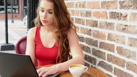 Female college student working on computer with coffee at cafe 4k Video stock 50934243