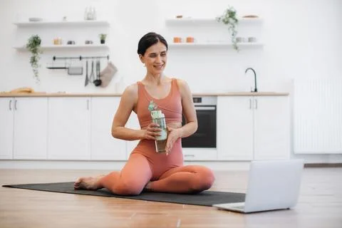 Female communicating with trainer using video app on laptop Stock Photos