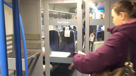 Female commuters entering first class compartment of a departing train. Stock Footage 99060282