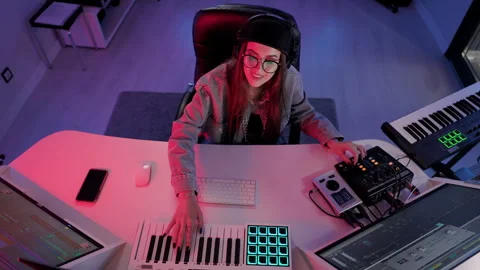 A female composer is captured in a top-down shot while working in her music Stock Footage 283676565