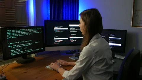Female computer code programmer coding and programming fast in an Stock Footage 254660967