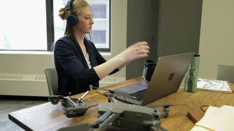 Female computer programmer with headphones programming virtual reality simulator Stock Footage 220345255