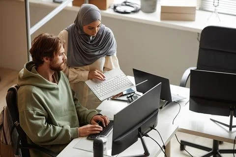 Female Computer Programmer Wearing Headscarf in Office During Code Review Foto stock