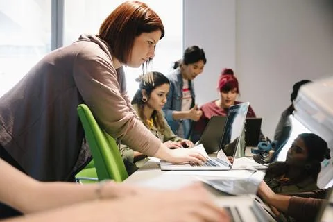 Female computer programmers coding at laptops in office Foto stock
