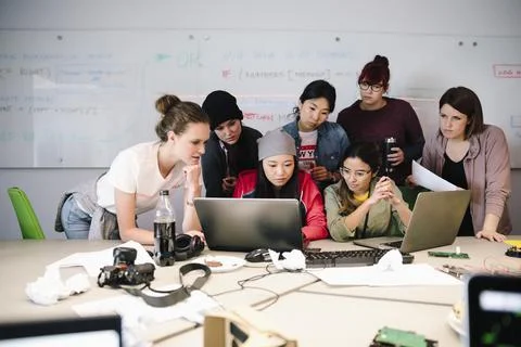 Female computer programmers coding at laptops in conference room 写真素材