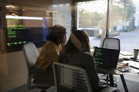 Female computer programmers working at laptop in conference room meeting Stock-Fotos