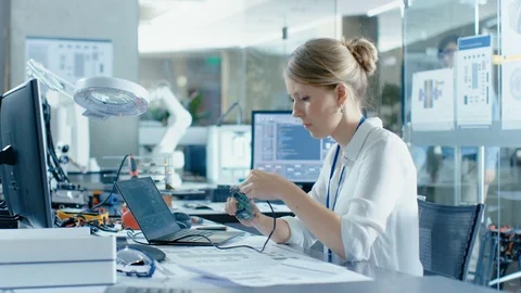 Female Computer Scientists Connects Circuit Board to Her Laptop with Mock-up Stock Footage 85769272