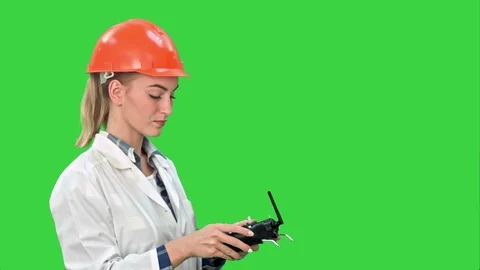 Female construction worker operating a crane using remote control on a Green Vídeos de archivo 73875068