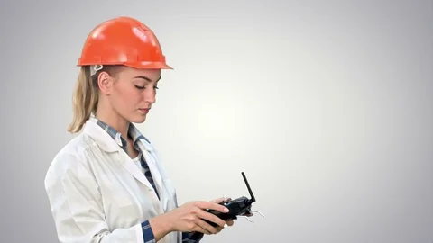 Female construction worker operating a crane using remote control on white Vídeo Stock 74216930