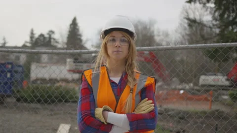 Female Construction Worker Standing in Front of Fenced Construction Site Video stock 208778035
