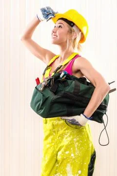 Female construction worker with tool bag indoors Stock Photos