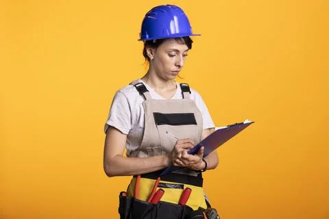 Female construction worker writing notes on clipboard Stock Photos