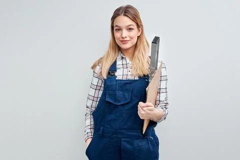 Female constructor builder holding paper clipboard posing at camera Fotos de archivo
