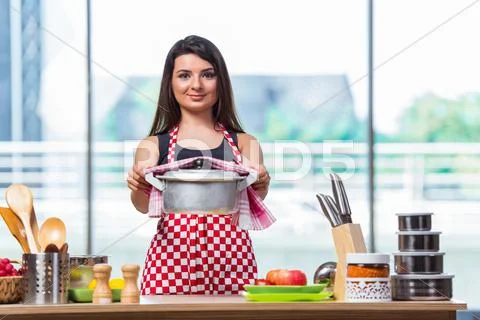 Female Cook Preparing Soup In Brightly Lit Kitchen