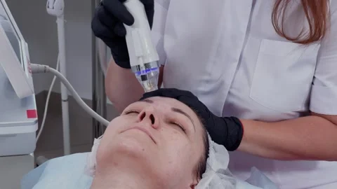 Female cosmetologist performs RF lifting procedure on a client 库存影片 337737892