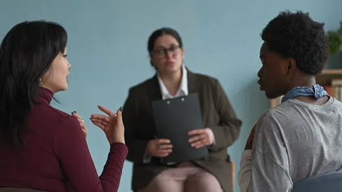 Female Counselor Defusing Conflict between Diverse Teens Having Disagreement Stock Footage 307484685