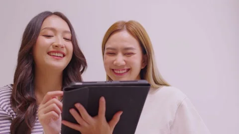 Female Couple using digital tablet shopping online and researching online on  Video stock 196900266