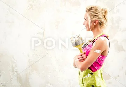 Female in coverall holding paint brush Stock Photos