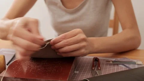 Female craftswoman sewing leather bag Stock Footage