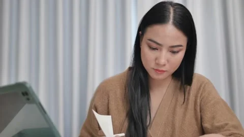 A female creator is taking notes in a notebook working on books  Stock Footage 197481094